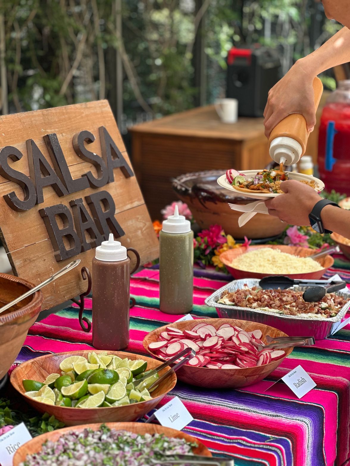 Outdoor buffet with taco toppings and condiments